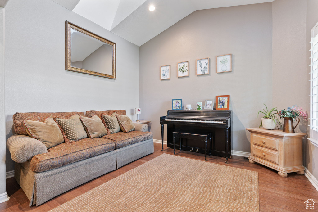 Living room with wood-type flooring and vaulted ceiling