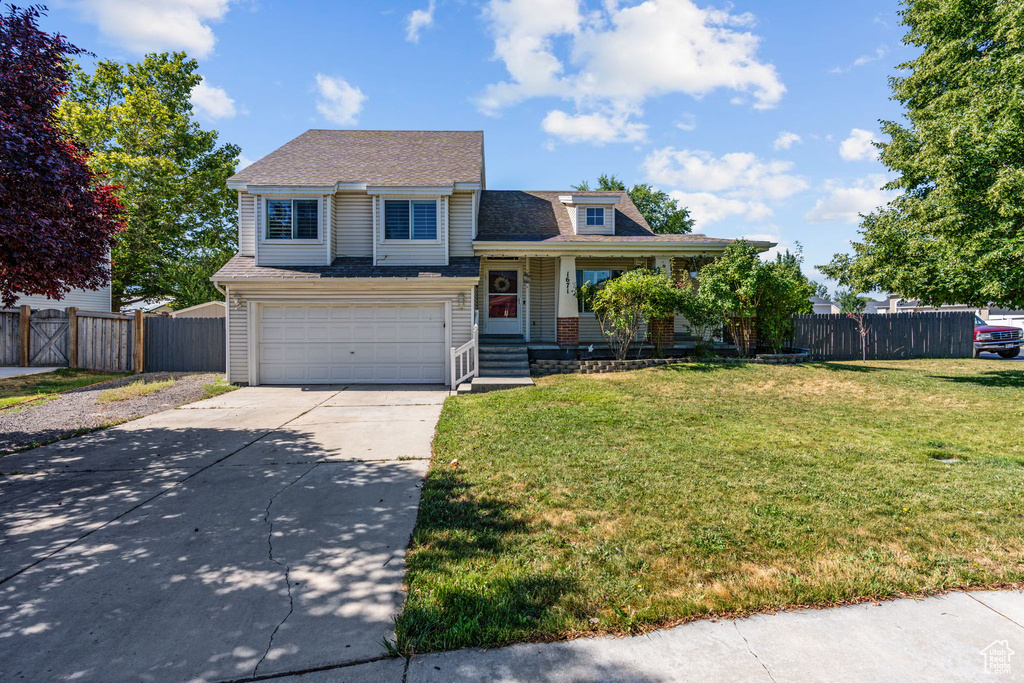 View of front of property featuring a garage and a front yard