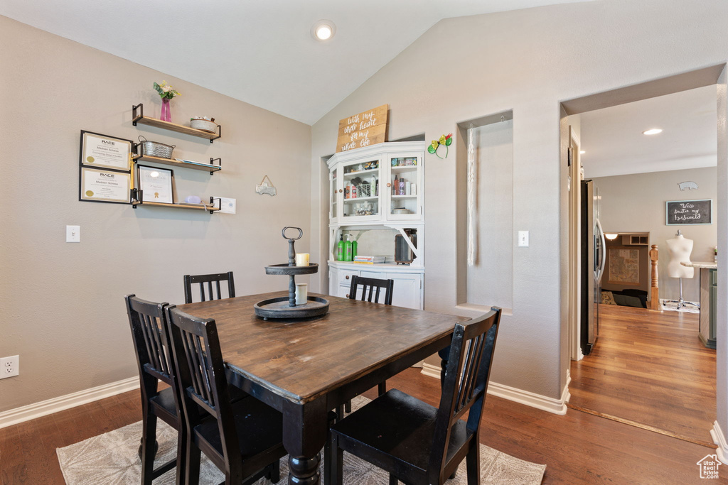 Dining area featuring dark hardwood / wood-style floors and vaulted ceiling