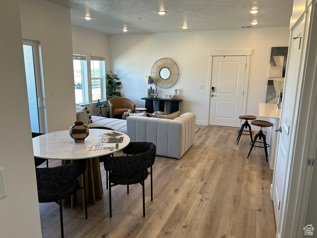 Dining room with a textured ceiling and light hardwood / wood-style floors