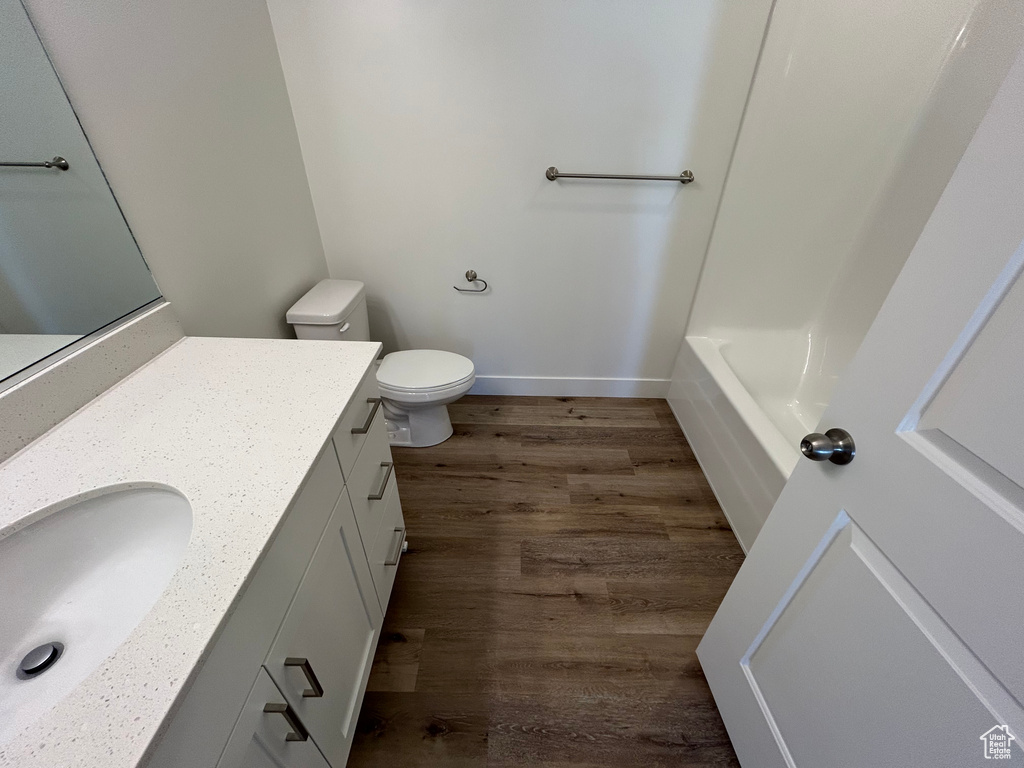 Full bathroom featuring vanity, shower / bathing tub combination, wood-type flooring, and toilet