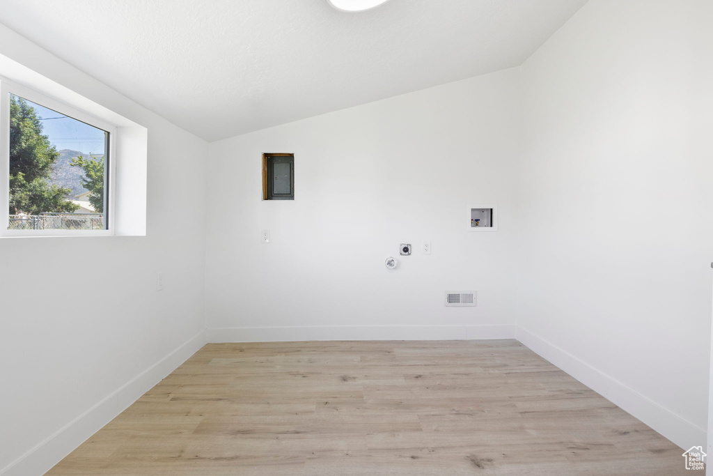 Clothes washing area featuring light hardwood / wood-style flooring, hookup for a washing machine, and electric dryer hookup