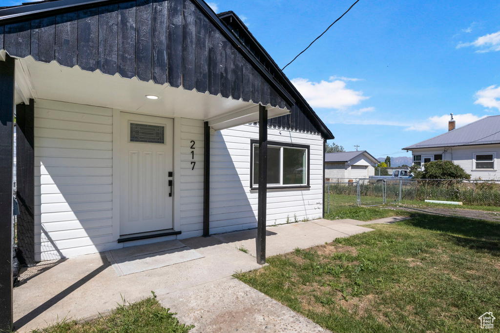 View of exterior entry featuring a lawn