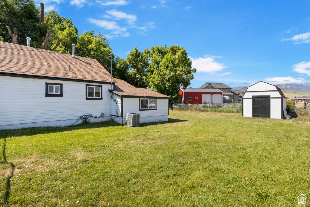 View of yard with cooling unit and a shed