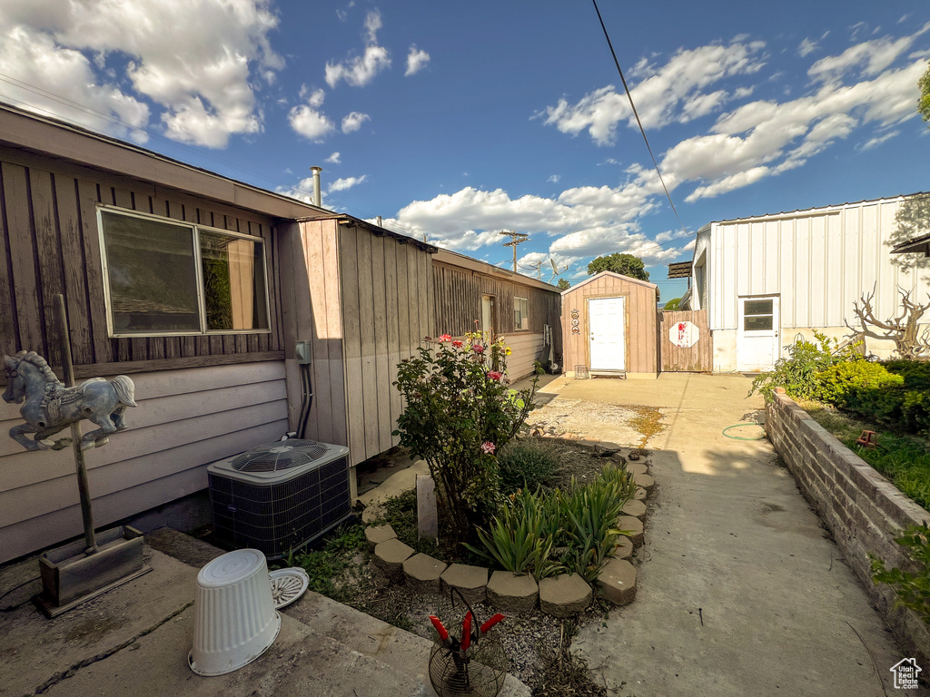 View of patio with cooling unit and a shed