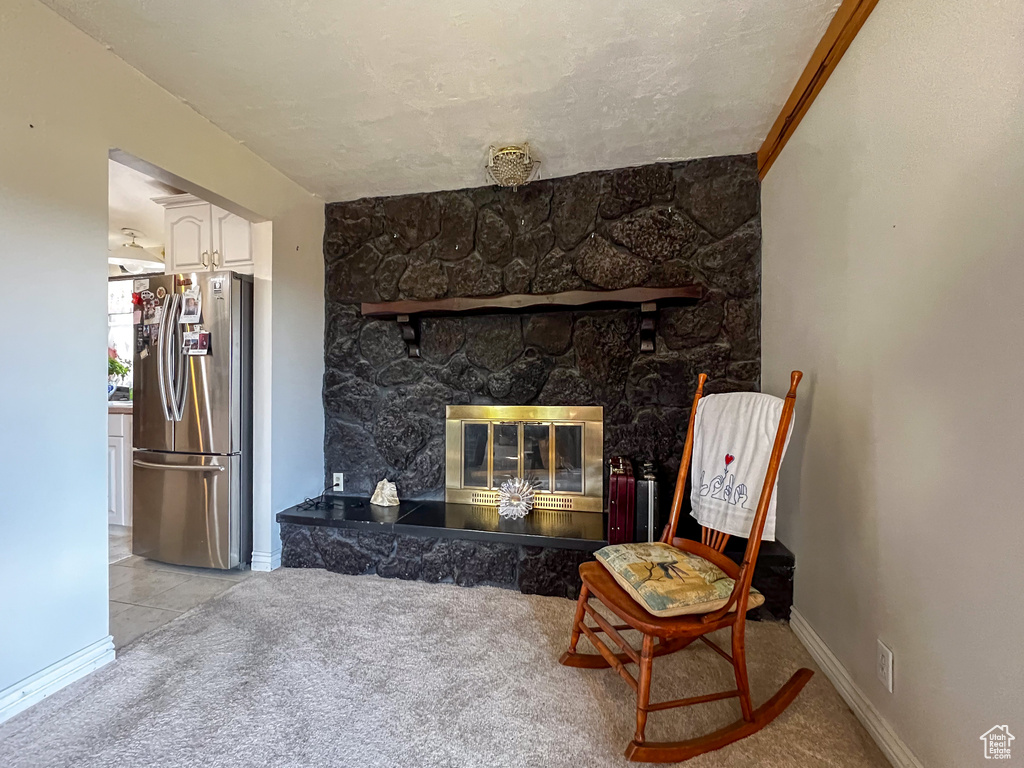 Living area featuring a fireplace and light carpet