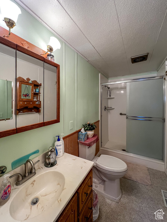 Bathroom with toilet, vanity, and an enclosed shower