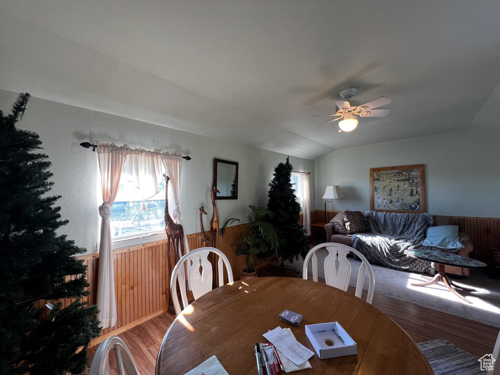 Dining room featuring wood-type flooring, vaulted ceiling, and ceiling fan