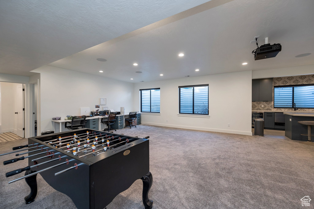 Game room with light carpet and sink