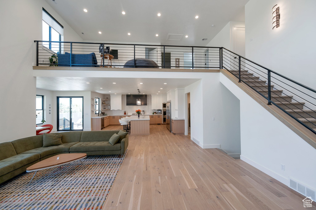 Living room featuring light hardwood / wood-style flooring and a towering ceiling