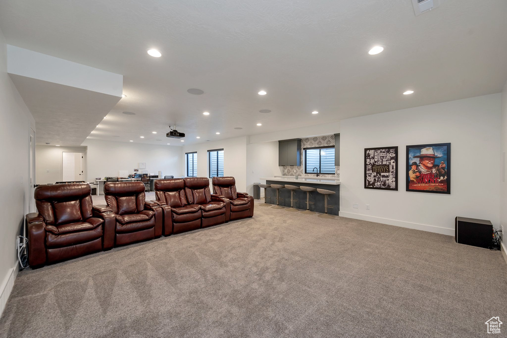 Carpeted home theater room featuring sink