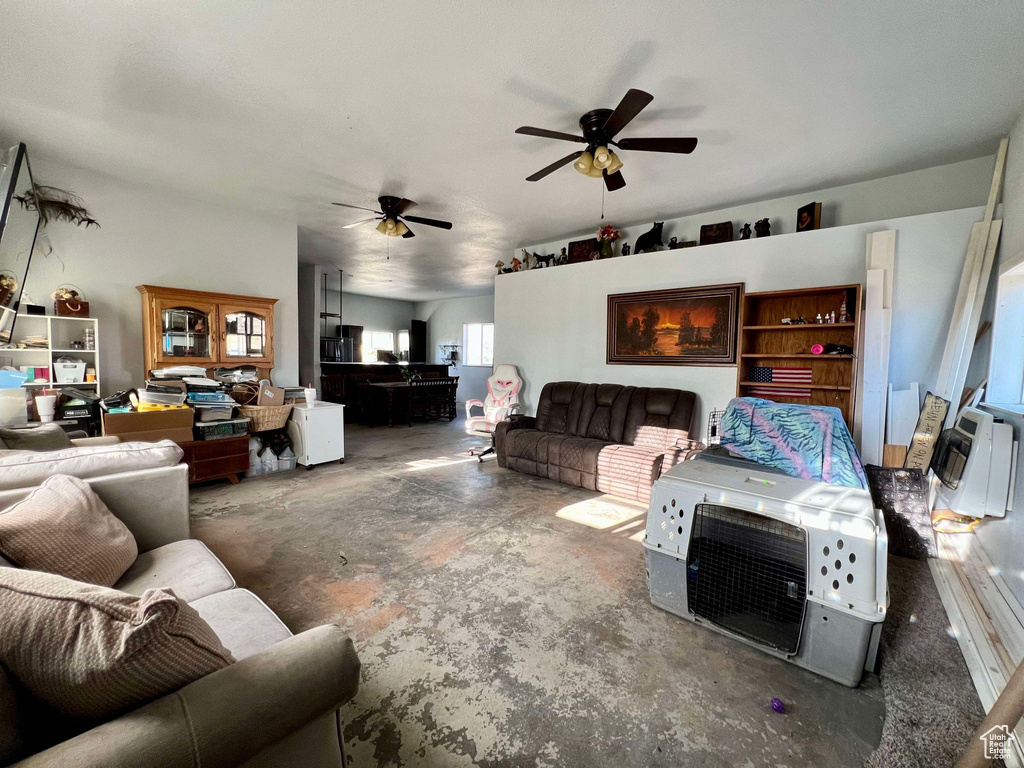 Living room with concrete flooring and ceiling fan