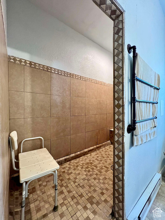 Bathroom with tile walls, baseboard heating, and tile patterned floors