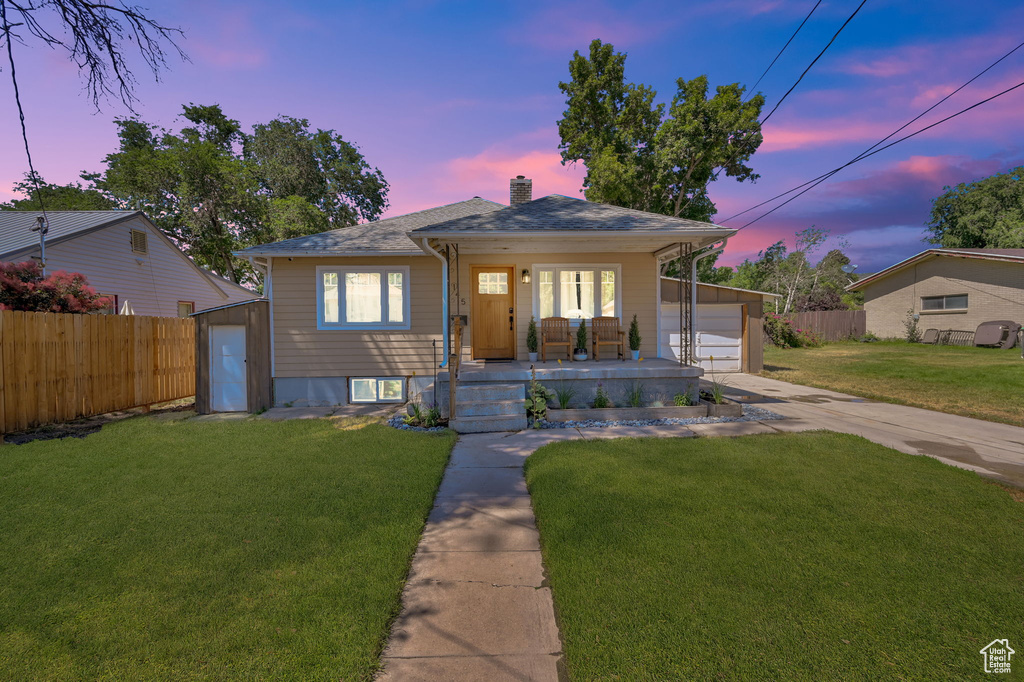 Bungalow-style house with a garage and a lawn