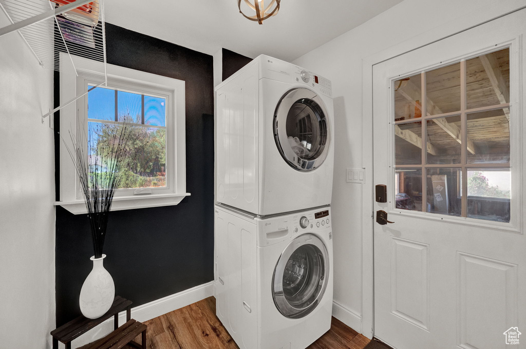 Laundry room with stacked washer / dryer and hardwood / wood-style flooring