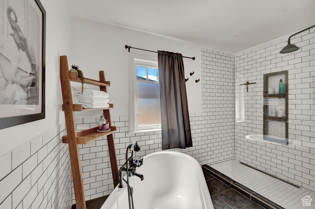 Bathroom featuring independent shower and bath, tile patterned flooring, and tile walls