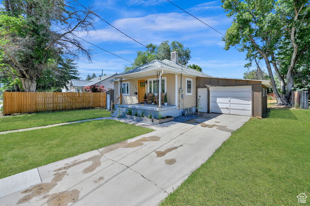 Single story home with a garage and a front yard