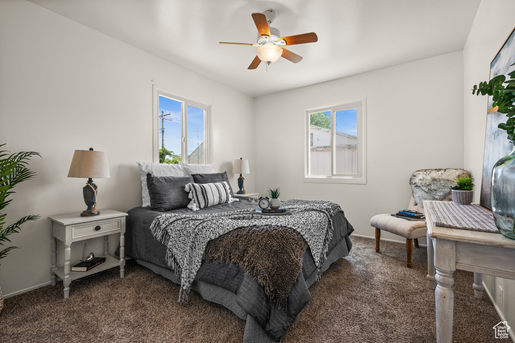 Bedroom featuring ceiling fan and dark carpet