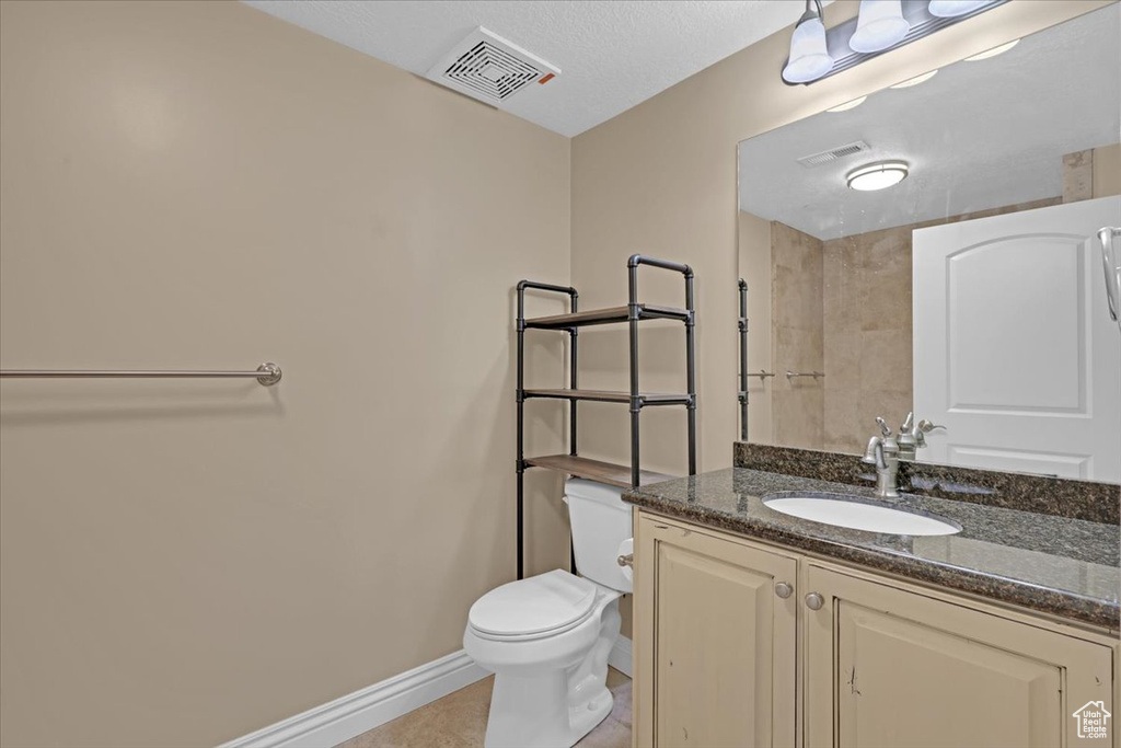 Bathroom featuring tile patterned floors, vanity, and toilet