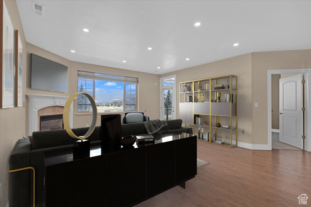 Living room with hardwood / wood-style floors and a high end fireplace