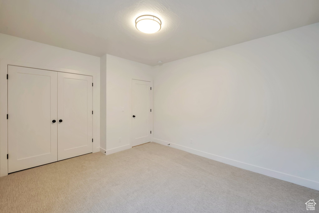 Unfurnished bedroom with a closet and light colored carpet