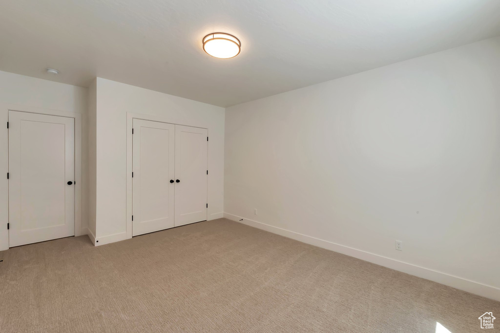 Unfurnished bedroom featuring carpet and a closet