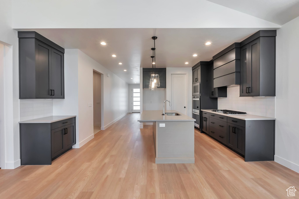 Kitchen featuring sink, light hardwood / wood-style flooring, and tasteful backsplash