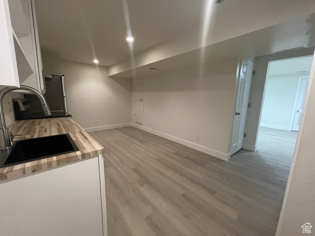 Kitchen featuring sink, wood-type flooring, stainless steel fridge, and butcher block counters