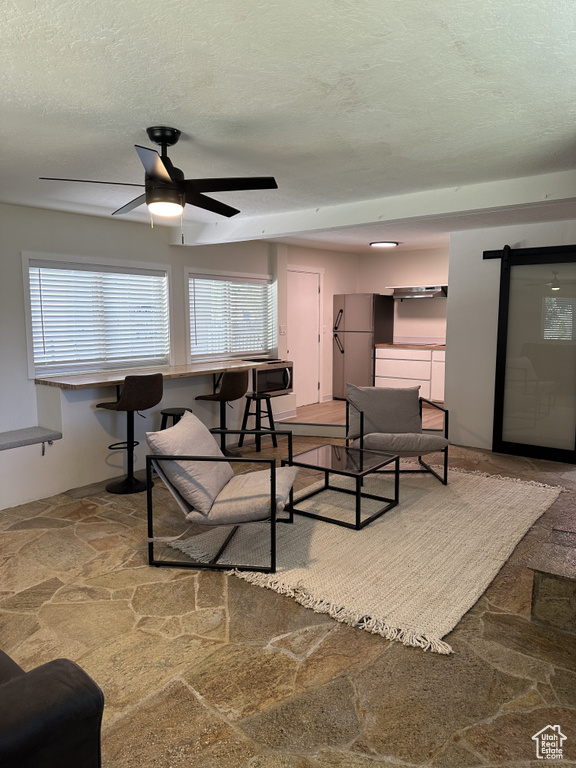 Living room featuring a textured ceiling and ceiling fan