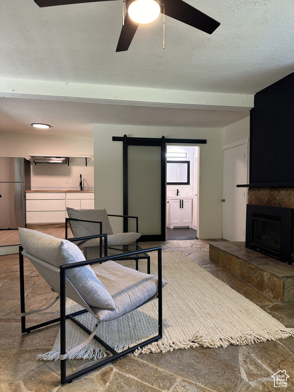 Living room with a textured ceiling, sink, and ceiling fan