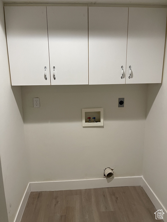 Laundry area with electric dryer hookup, washer hookup, cabinets, and hardwood / wood-style floors