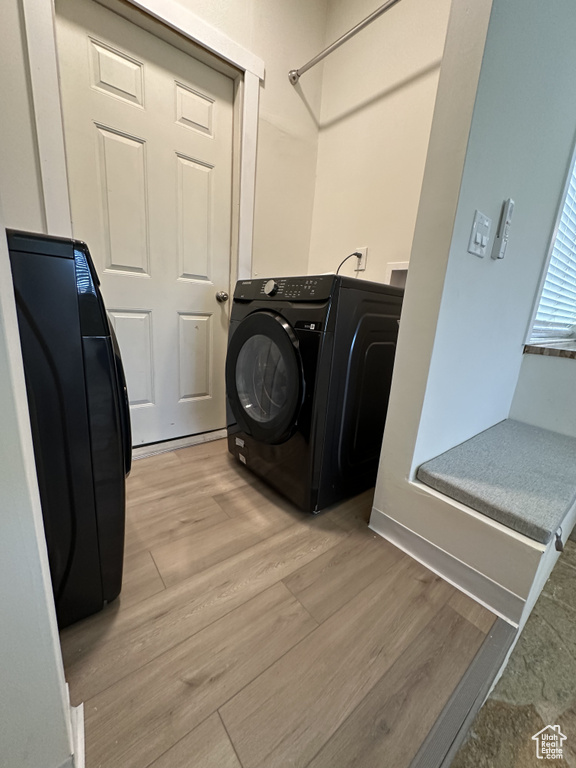 Laundry room with washer / dryer and light hardwood / wood-style floors