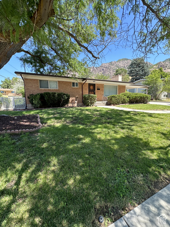 Ranch-style house featuring a front lawn and a mountain view