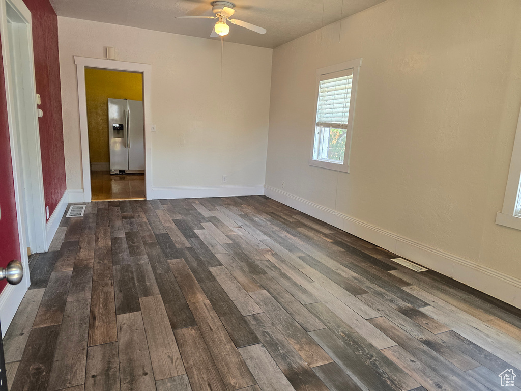 Spare room with dark hardwood / wood-style flooring and ceiling fan