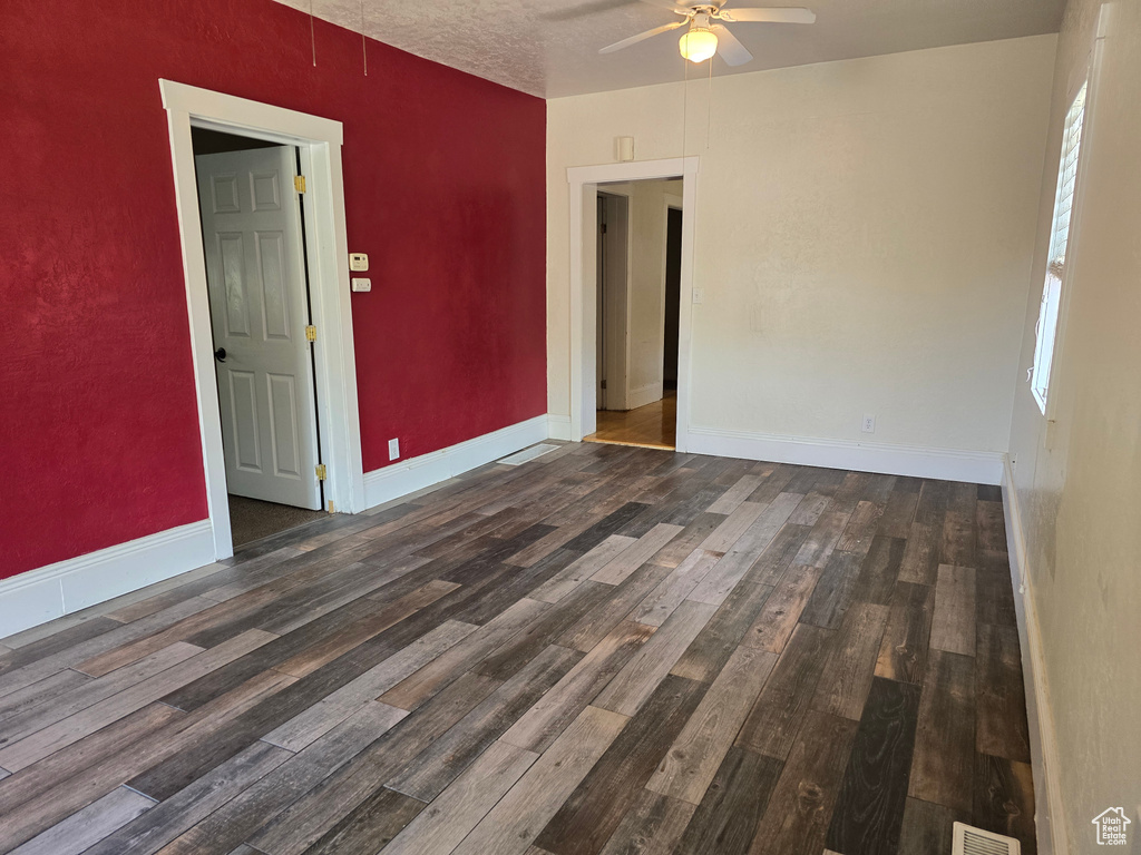 Spare room with ceiling fan, a textured ceiling, and dark hardwood / wood-style flooring