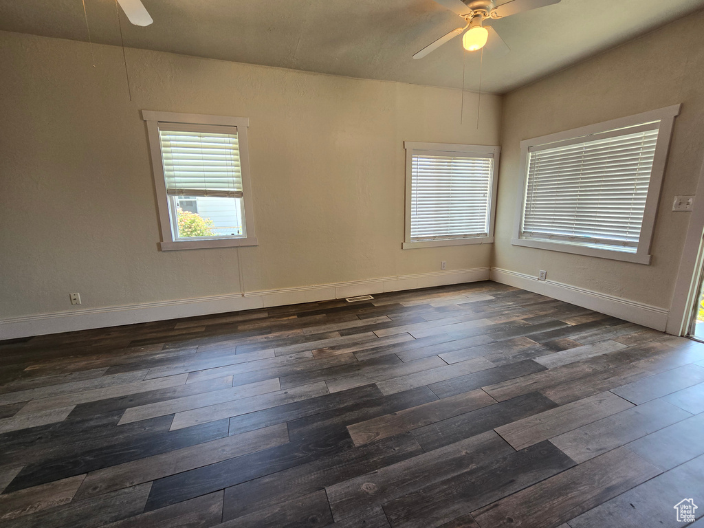 Spare room with dark hardwood / wood-style flooring and ceiling fan