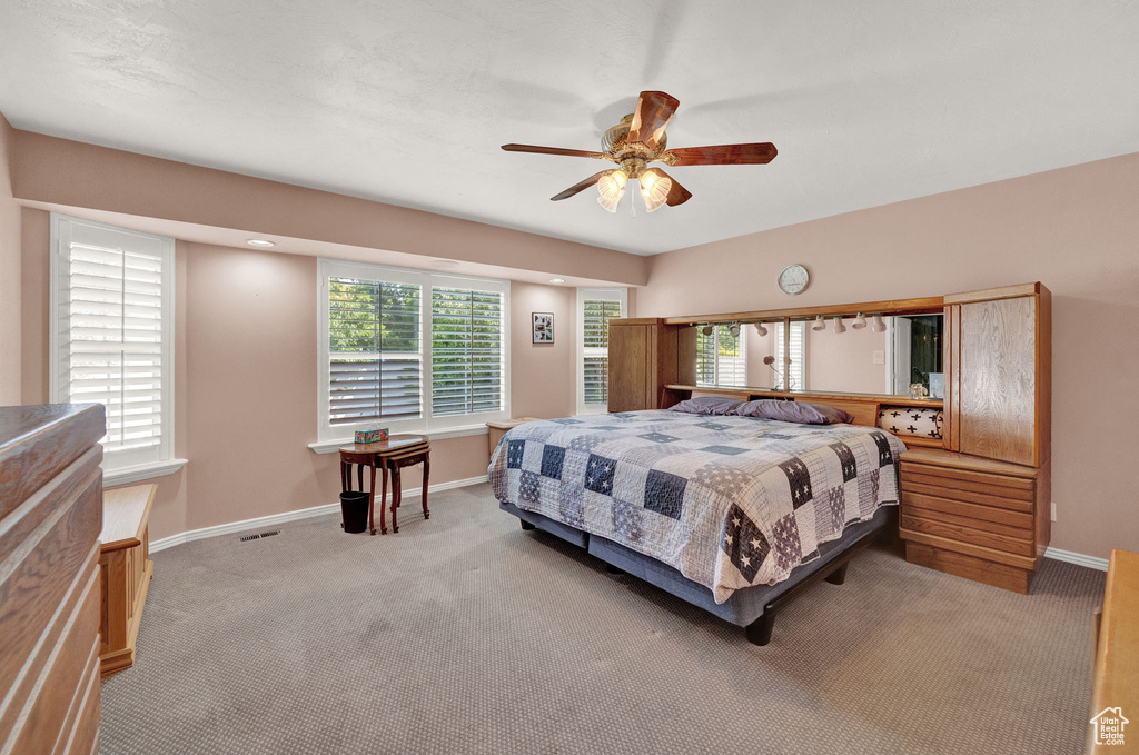 Carpeted bedroom featuring ceiling fan