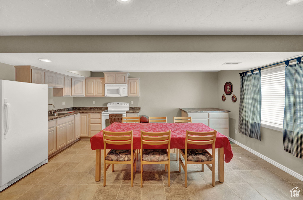 Tiled dining space featuring sink