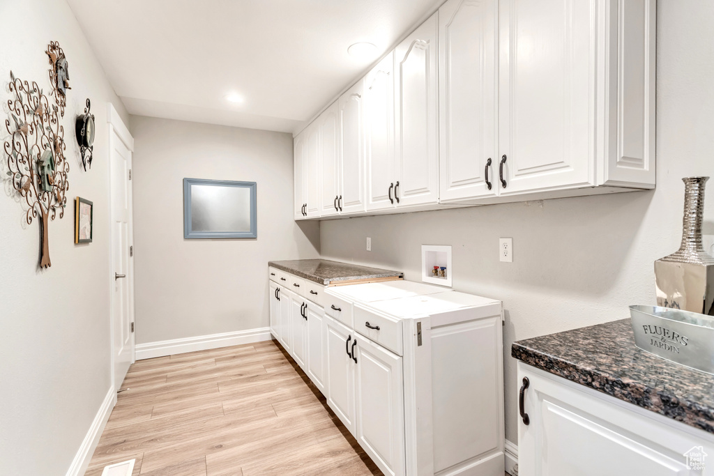 Laundry area featuring cabinets, washer hookup, and light wood-type flooring