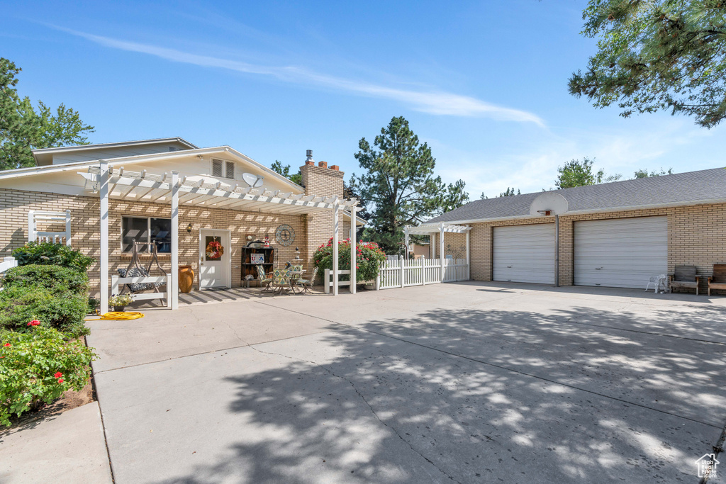 View of front of home featuring a pergola and a garage