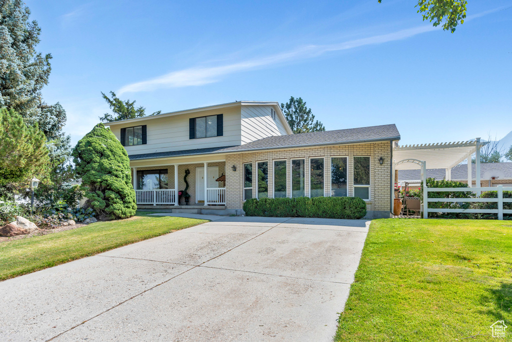 View of property with a porch and a front yard