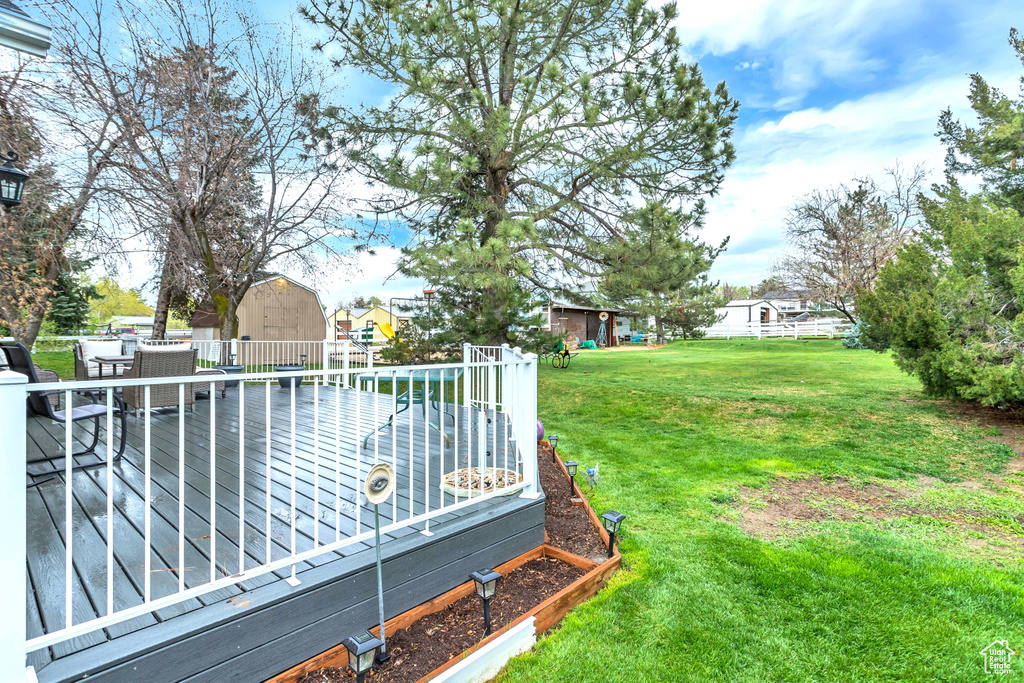 View of yard featuring a storage shed and a deck