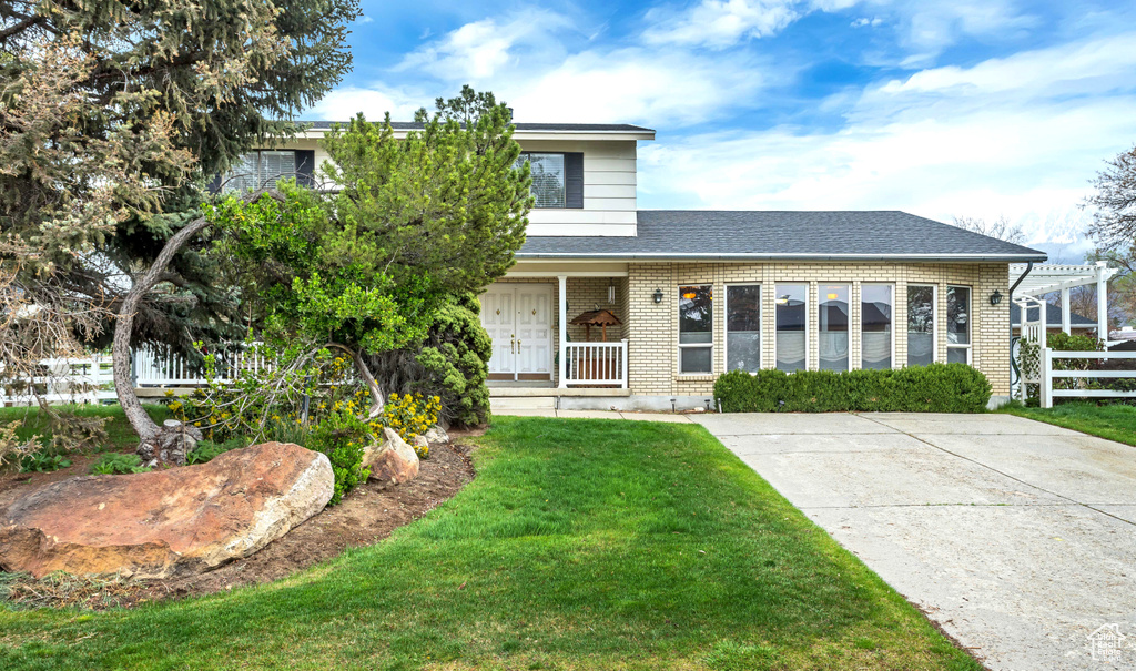 View of front of property featuring covered porch and a front lawn