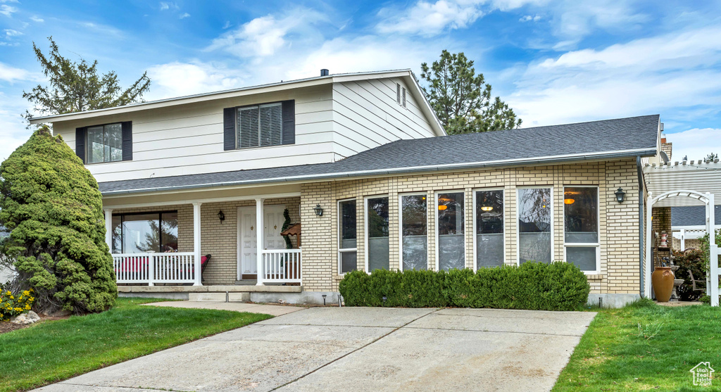 View of front facade featuring a porch and a front lawn