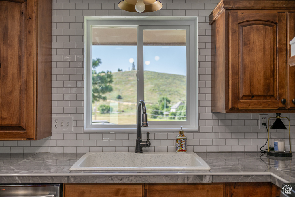 Kitchen with sink, stainless steel dishwasher, and decorative backsplash