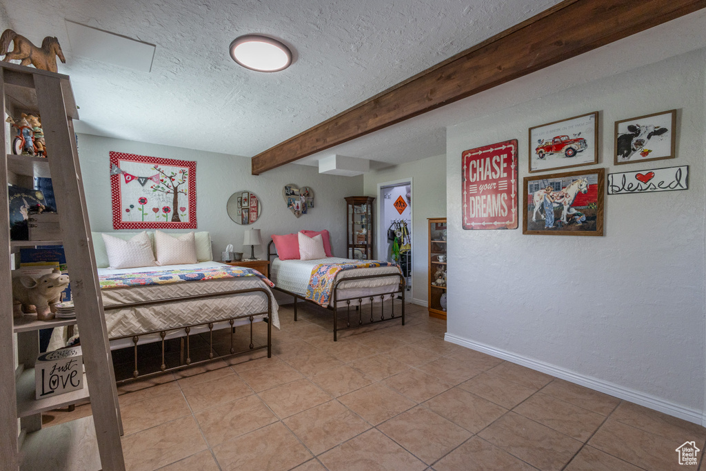 Tiled bedroom with beamed ceiling and a textured ceiling