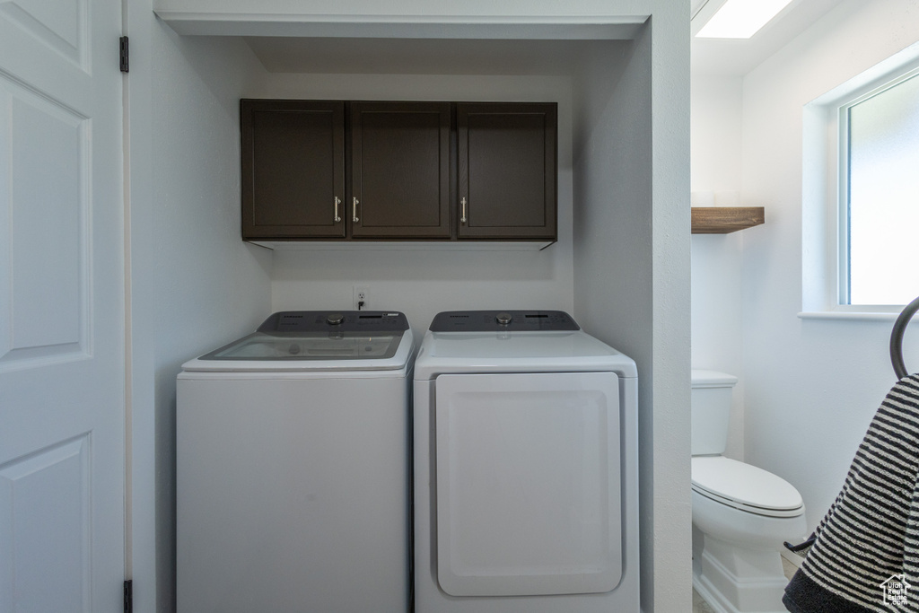 Clothes washing area with separate washer and dryer and plenty of natural light