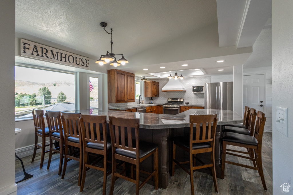 Dining room featuring sink, dark hardwood / wood-style flooring, lofted ceiling, and a chandelier