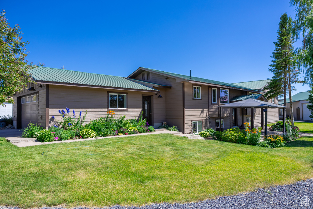 View of front of house featuring a front lawn and a garage