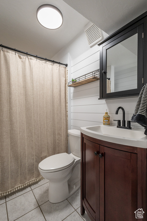 Bathroom with tile patterned floors, toilet, and vanity